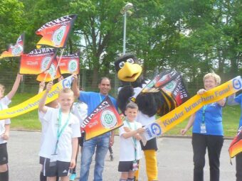 Begrüßung vor dem Spiel. DFB Maskottchen "Paule" trifft PLAN beim Stadionrundgang