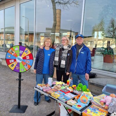 Plan-Freiwillige vor Stand mit Glücksrad
