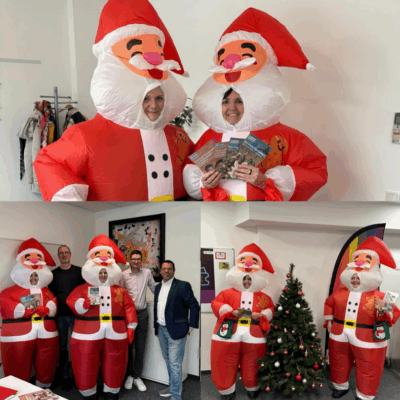 Eine Collage aus drei Fotos zeigt zwei Personen in aufblasbaren Weihnachtsmannkostümen. Auf dem oberen Bild halten sie Broschüren und lächeln. Auf dem Bild unten links sind drei weitere Personen in Geschäftskleidung zu sehen. Das Bild unten rechts zeigt sie an einem geschmückten Weihnachtsbaum, immer noch mit Prospekten in der Hand.