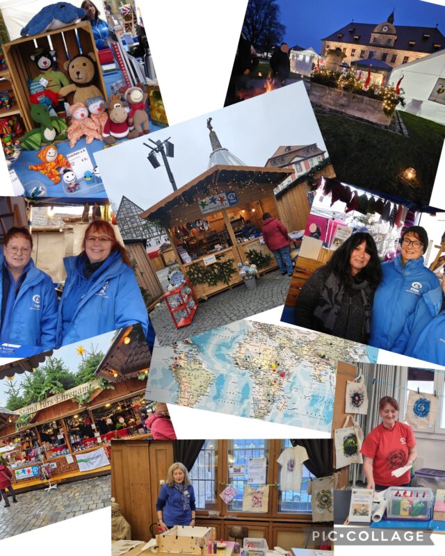 Eine Fotocollage von einem festlichen Markt im Freien: Menschen in blauen Jacken, handgefertigtes Kunsthandwerk, ausgestopfte Tiere, dekorierte Stände, eine Weltkarte und ein historisches Gebäude in der Abenddämmerung. Lächelnde Verkäufer und bunte Waren schaffen eine fröhliche, gemeinschaftliche Atmosphäre.