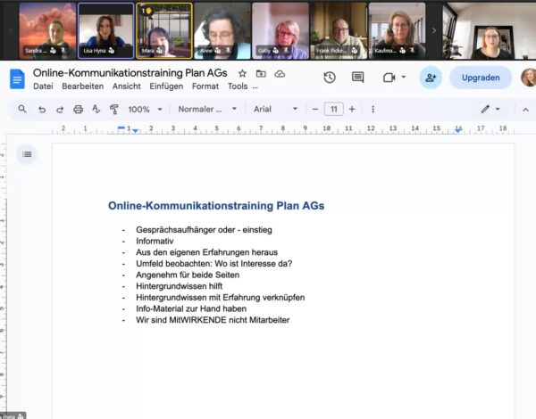 Ein Screenshot einer Videokonferenz mit acht sichtbaren Gesichtern der Teilnehmer im oberen Bereich. Unten zeigt ein gemeinsam genutzter Google Docs-Bildschirm einen deutschen Text mit dem Titel Online-Kommunikationstraining Plan AGs mit einer Aufzählung von Punkten auf weißem Hintergrund.