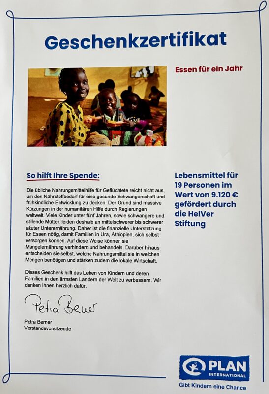 Ein deutscher Geschenkgutschein von Plan International mit einem Foto von lächelnden afrikanischen Kindern beim Essen. Auf der von Petra Beuys unterzeichneten Bescheinigung steht, dass eine Spende im Wert von 9.120 € 19 Menschen ein Jahr lang mit Lebensmitteln versorgt hat. Der Text erläutert die Wirkung der Spende.