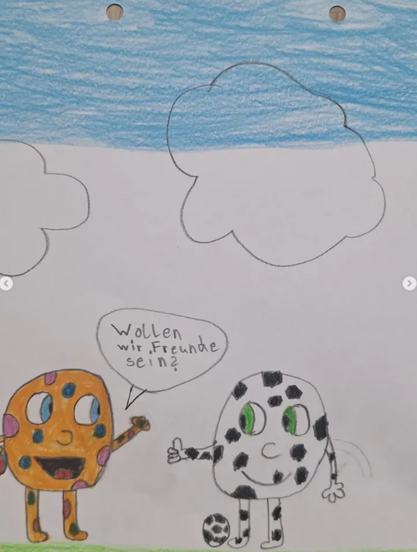 Die Zeichnung eines Kindes zeigt einen gepunkteten orangefarbenen Keks und einen schwarz-weißen Keks, die im Gras stehen. Auf dem orangefarbenen Keks steht: Wollen wir Freunde sein? (Deutsch für Wollt ihr Freunde sein?). Der Himmel ist blau mit großen weißen Wolken.