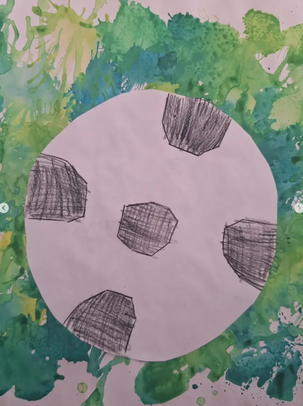 Eine Kinderzeichnung eines Fußballs mit fünf handgezeichneten schwarzen Fünfecken auf einem weißen Kreis vor einem grün-gelben Aquarell-Hintergrund, der ein lebendiges und verspieltes Aussehen vermittelt.