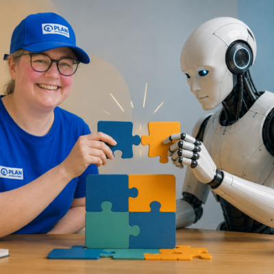 Eine lächelnde Person in einem blauen Hemd und einer Mütze sitzt neben einem humanoiden Roboter. Beide setzen an einem Tisch bunte Puzzleteile zusammen. An der Wand dahinter sind Abbildungen von Glühbirnen und Gehirnen zu sehen, die die Zusammenarbeit zwischen menschlicher Kreativität und künstlicher Intelligenz verdeutlichen.
